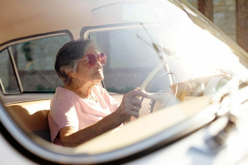 femme âgée au volant de sa voiture et bien assurée